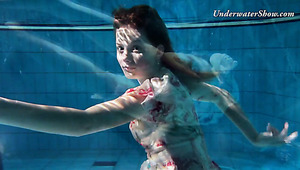 Appealing red haired Edwige swimming in a pool naked