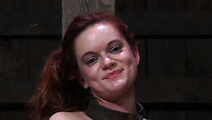 Perverse red-haired student gets her neck and legs locked into metal fetters