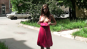 Dark haired lusty chick in pink dress tickles her kitty outdoors