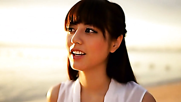 Slim Asian girl Yumi Sugimoto walks on a beach wearing white dress